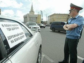 Милиционер у машины. Фото: с сайта kommersant.ru