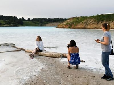 Девушки фотографируются на фоне золоотвала Новосибирской ТЭЦ-5. Фото: Александр Кряжев / РИА Новости