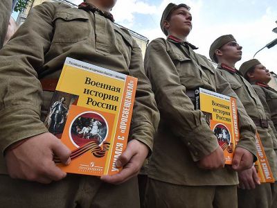 Школьники в военной форме, держат в руках учебник военной истории России на встрече актива Российско военно-исторического общества. Фото: Дмитрий Лебедев / Коммерсант