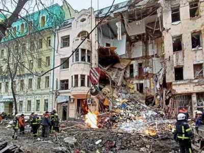 Спасатели работают возле здания в центре Харькова, поврежденного в результате авиаудара. 14 марта 2022 года Vitalii Hnidyi / Reuters